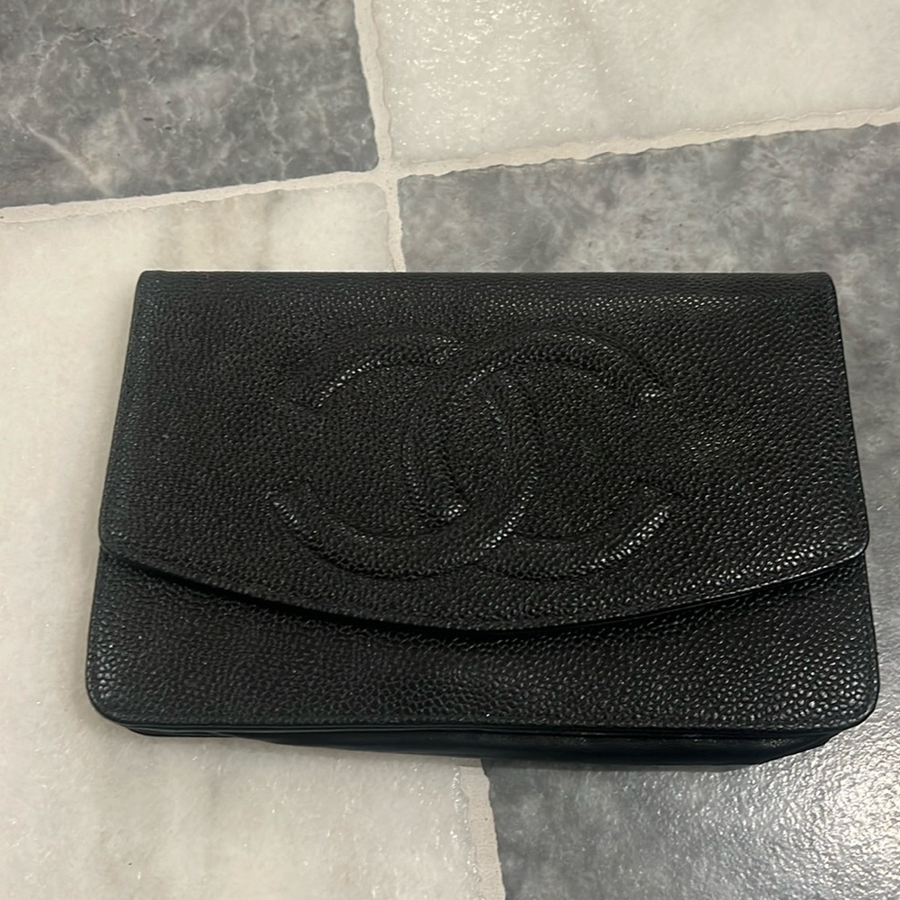 Authentic Chanel wallet on chain in black caviar with gold hardware.